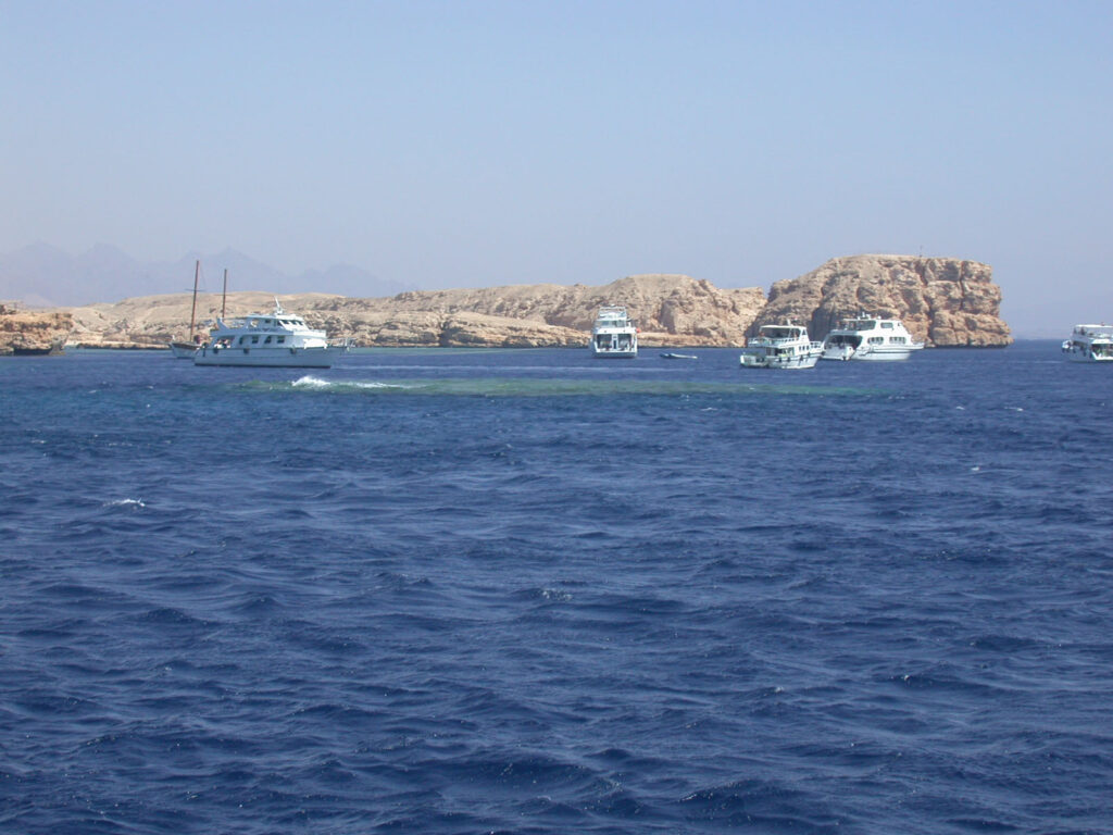Tauchboote vor Anker vor den hellen Klippen von Ras Mohammed, über dem Shark und Yolanda Reef