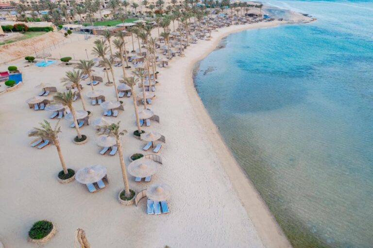 Luftaufnahme des Strands am Blend Elphistone Resort mit Palmen, Strohschirmen und türkisfarbenem Meer