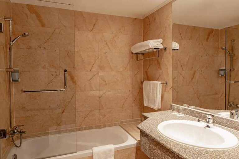 Ein Marmorbad mit Badewanne, Dusche und Waschbecken