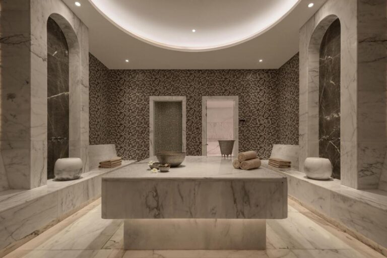 Ein mit Marmor verkleideter Raum im Spa des JAZ Elite Riviera, mit einem großen Steintisch in der Mitte