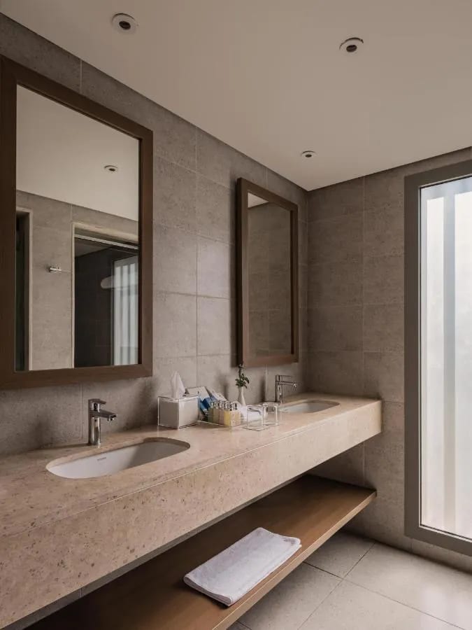 Ein Bad mit Waschbecken und großem Spiegel