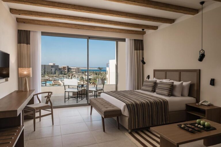 Ein Zimmer mit Doppelbett und Balkon, mit Blick auf die Pools und das Rote Meer