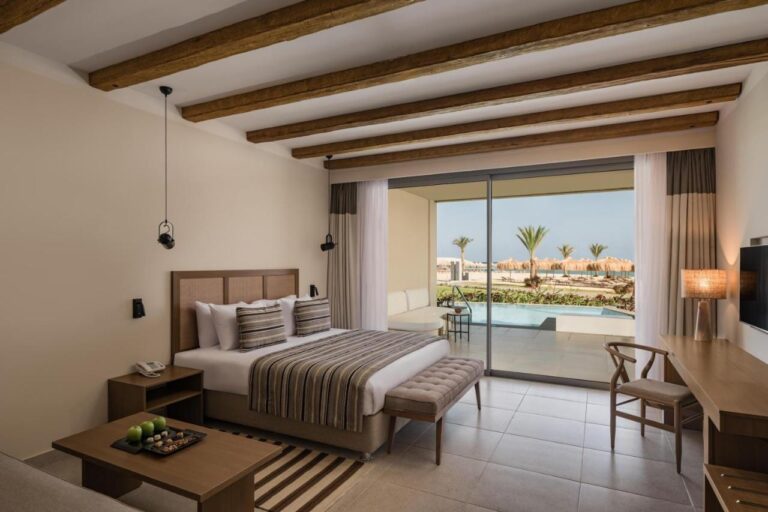 Ein Zimmer mit Doppelbett, offen zu einem Pool