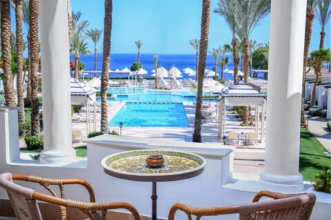 Der Blick von einer Terrasse des JAZ Fanara Resorts auf die Pools, die Palmen und das Rote Meer