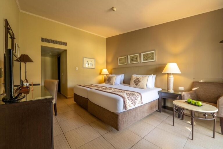 Ein Zweibettzimmer mit Sessel und einem Couchtisch mit grünen Äpfeln
