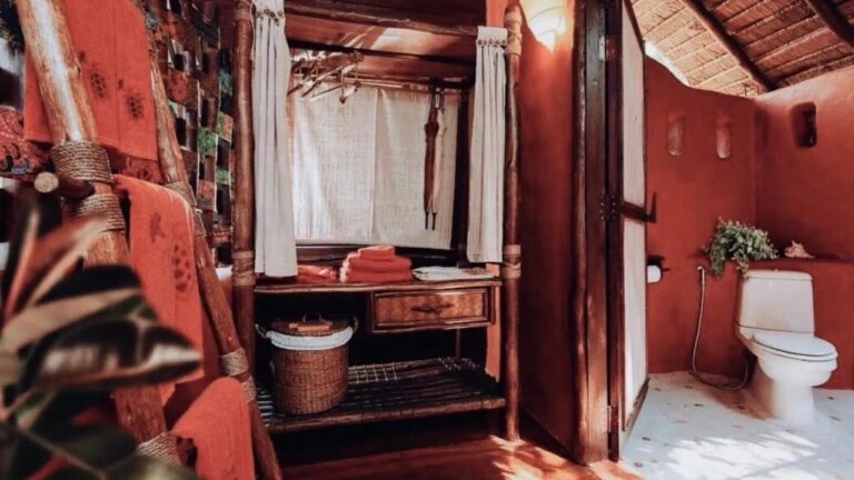 Ein Kleiderschrank, orangefarbene Handtücher und eine Toilette vor roten Wänden