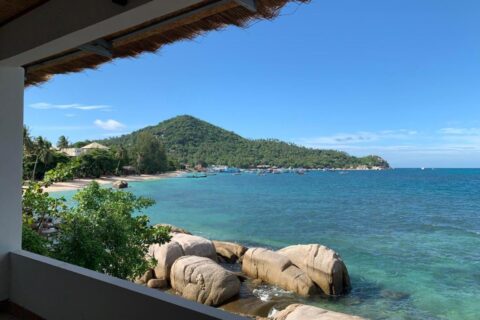 Die Bucht mit ihren Felsen und ankernden Booten, von einer überdachten Terrasse des Koh Tao Heritage aus gesehen