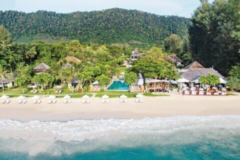 Das Layana Resort vom Meer aus, mit Strand, weißen Sonnenschirmen, Pool und Dächern unter Palmen