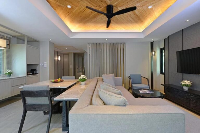 Ein Wohnraum mit langem Sofa, Marmortisch und Kaffeemaschine