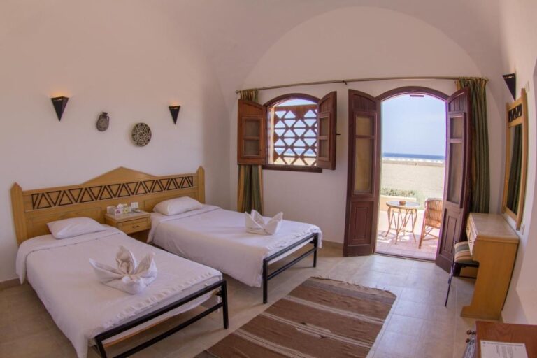 Ein Zweibettzimmer, offen zu einer Terrasse mit Blick auf den Strand und das Meer
