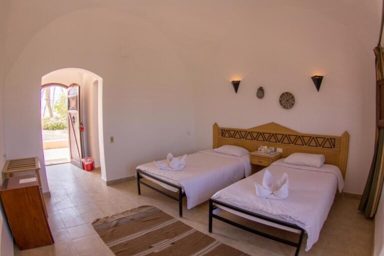 Ein Zweibettzimmer mit einem gewölbten Eingang, offen zum Garten
