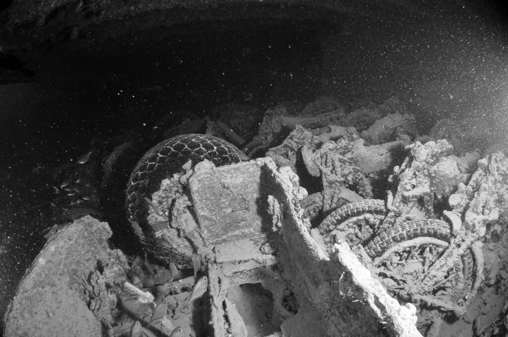 Gestapelte Motorräder im Laderaum der Thistlegorm, Schwarz-Weiß-Foto, Reifen und Räder noch sichtbar