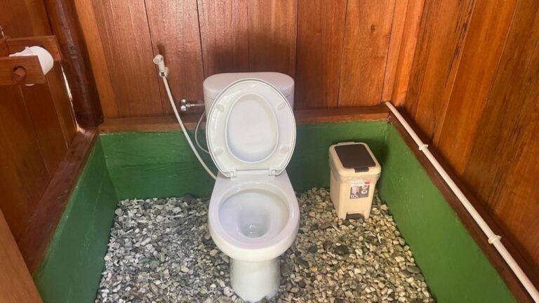 Eine Toilette mit Holzwänden und einem Kieselboden