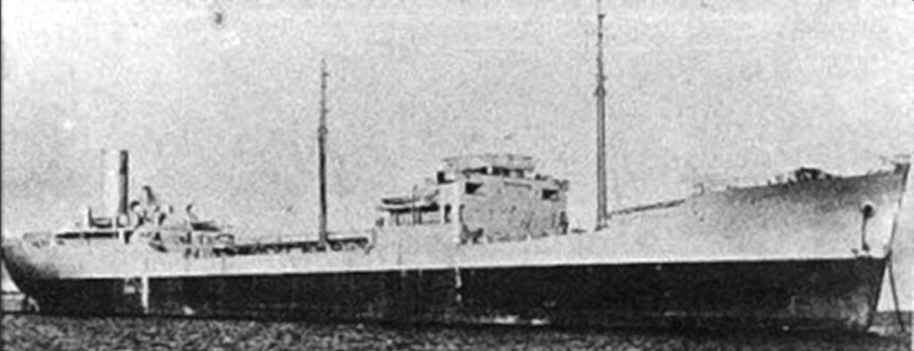 Körniges Schwarz-Weiß-Archivfoto eines Tankers im Profil, mit der Brücke in der Mitte, zwei Masten und dem Schornstein hinten.