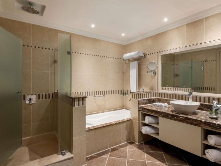 Ein Bad mit Glasdusche, Badewanne und Aufsatzwaschbecken