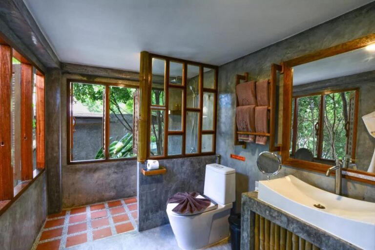 Ein Bad mit Dusche hinter einer holzgerahmten Glaswand
