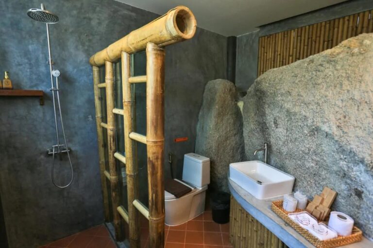 Ein Bad, an einen großen Felsen gebaut, mit Dusche und Waschbecken