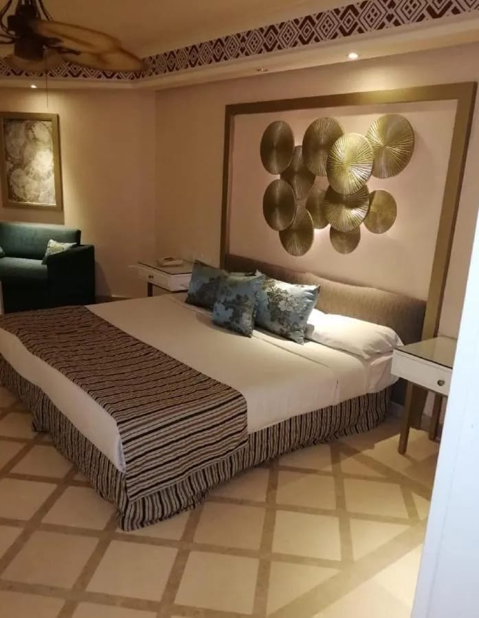 Ein Doppelbett unter einer Wanddekoration aus goldenen Scheiben
