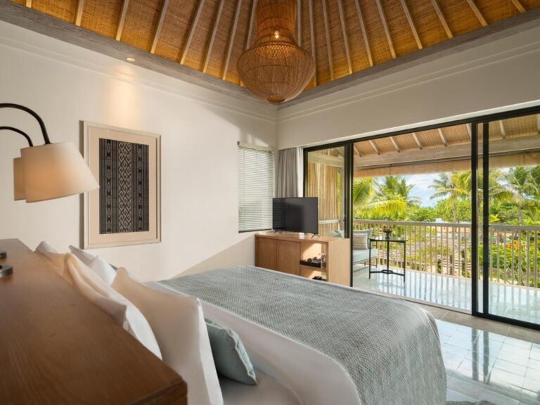 Ein Zimmer mit Korb-Hängelampe und Glasfront zum Balkon