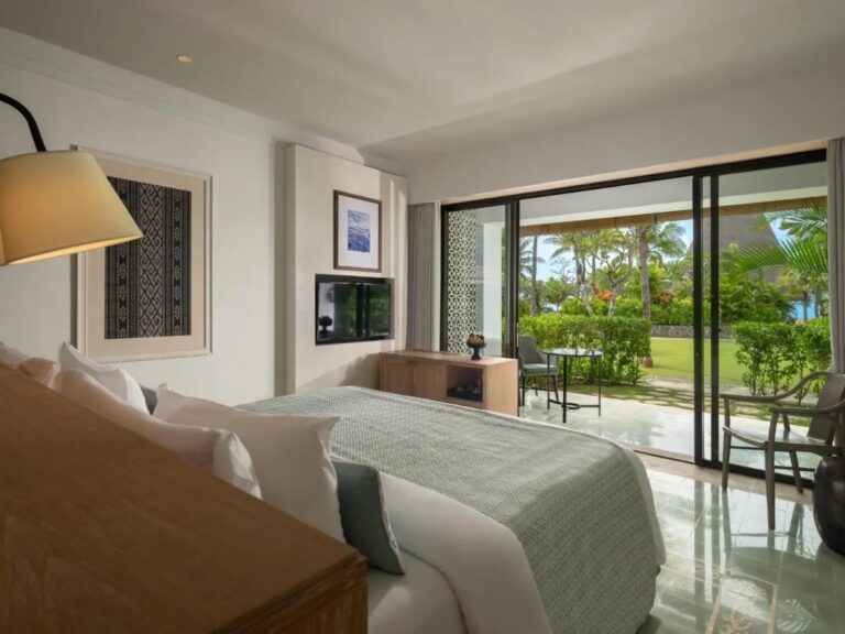 Ein Zimmer mit Doppelbett, offen zur Terrasse und zum Garten