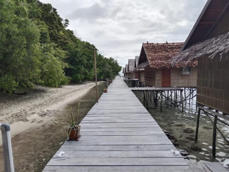 Ein Holzsteg zwischen dem Strand und den Stelzenbungalows