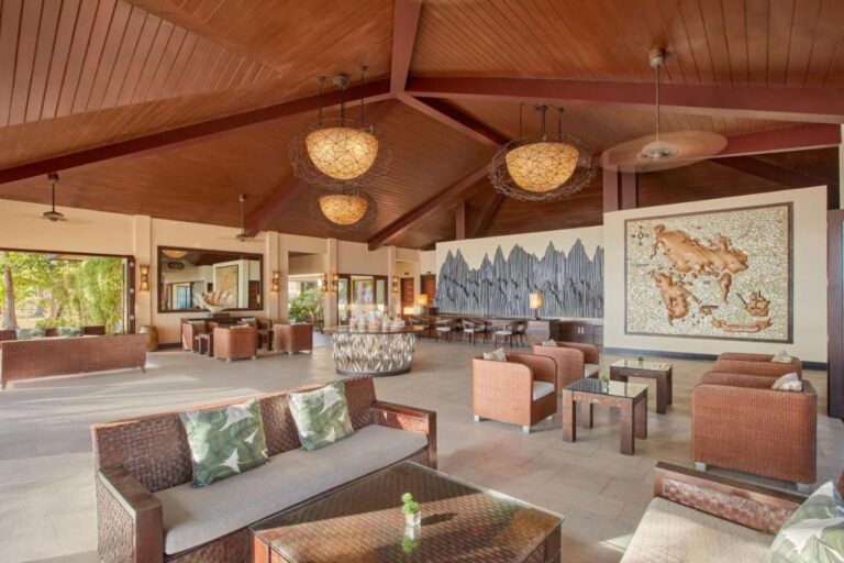 Die Lobby mit geflochtenen Sofas, großen Hängeleuchten und einer großen Wandkarte